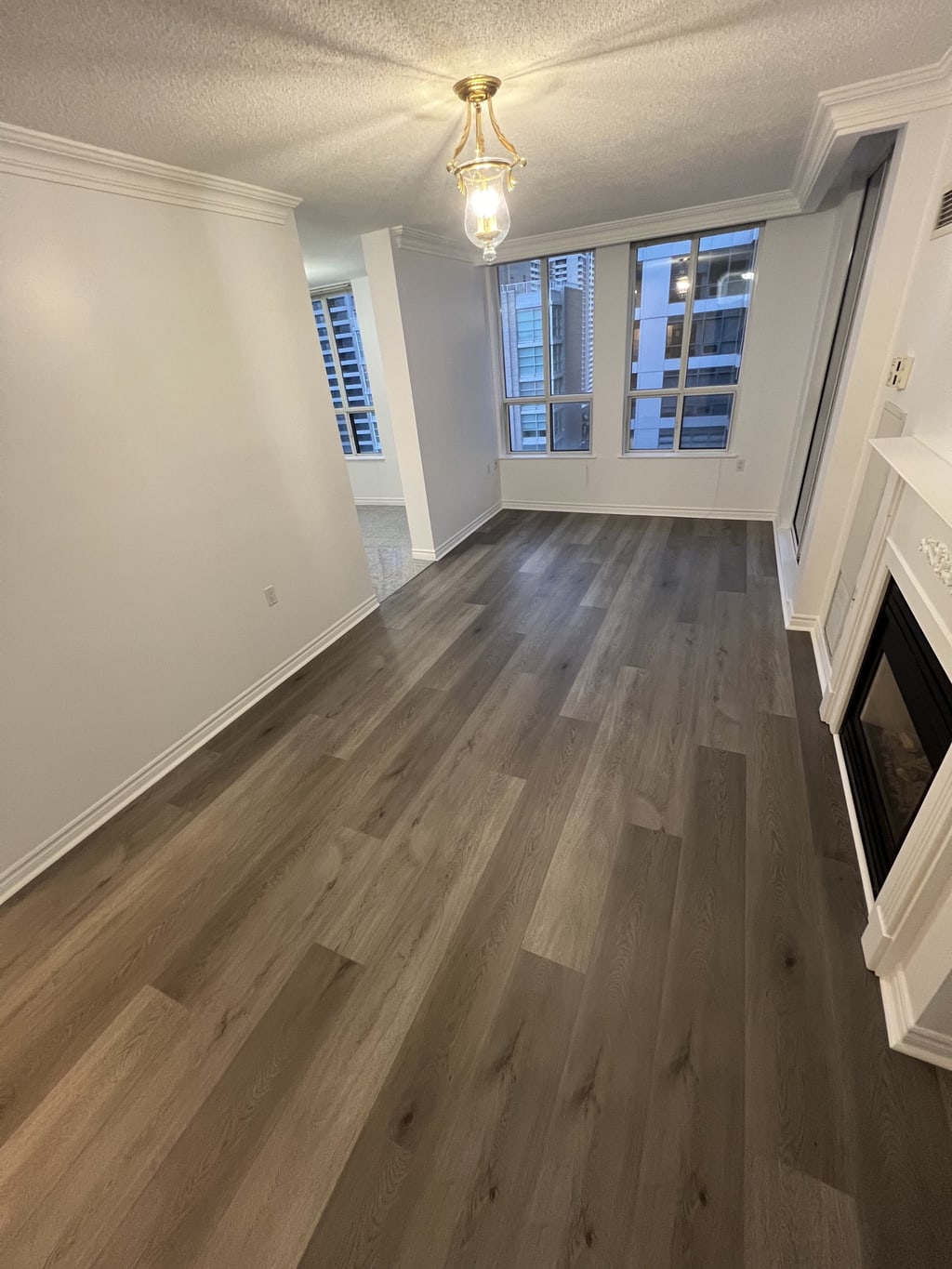 Finished grey wood-look flooring in a bright living room with white trim